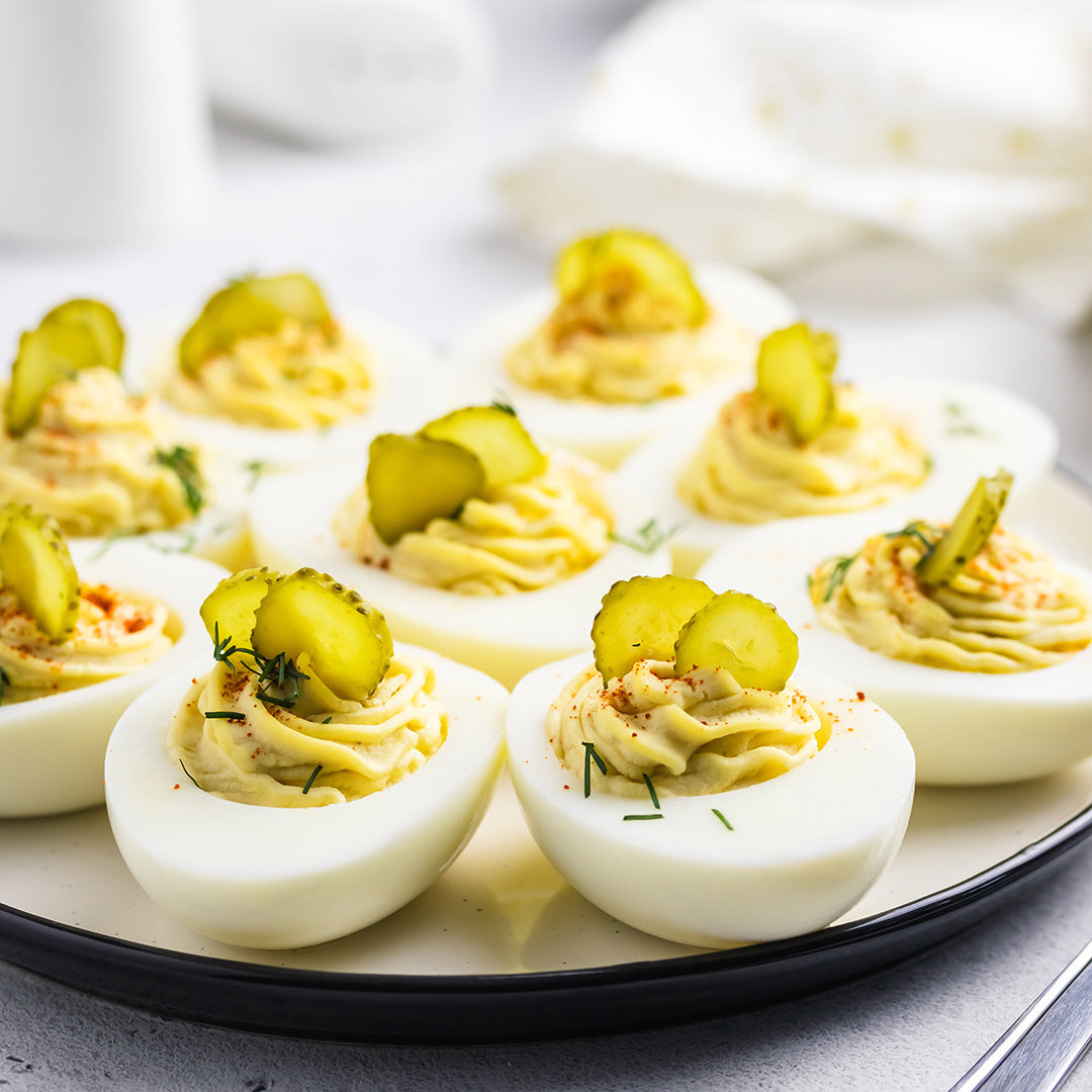 Deviled eggs topped with pickles dill and paprika