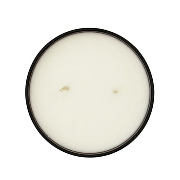 Round candle in a black container on a white background
