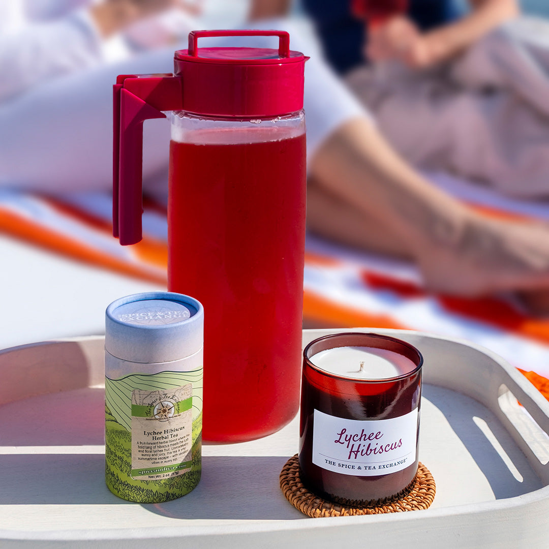 Lychee Hibiscus Candle and brewed tea and tea in paper decorative tube