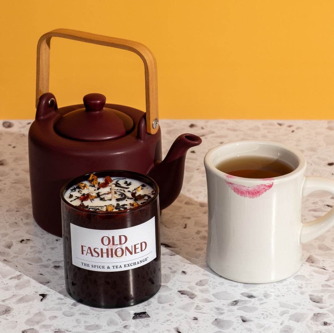 Old Fashioned Oolong Tea next to matching candle and plum teapot