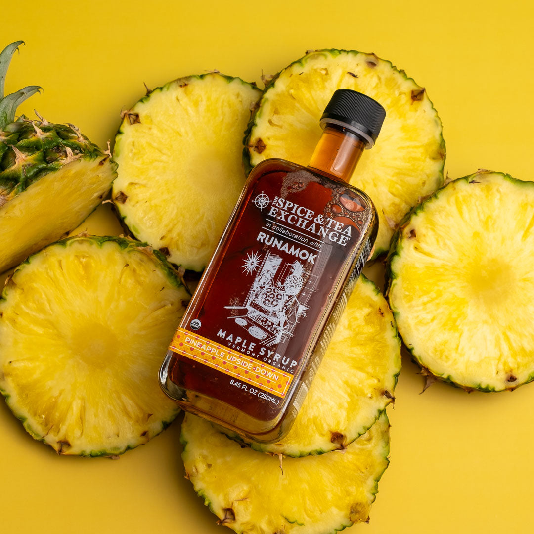 Pineapple Upside Down Maple Syrup on yellow background with pineapple slices