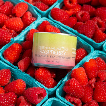 Ceremonial Matcha Raspberry product surrounded by raspberries in a teal container.