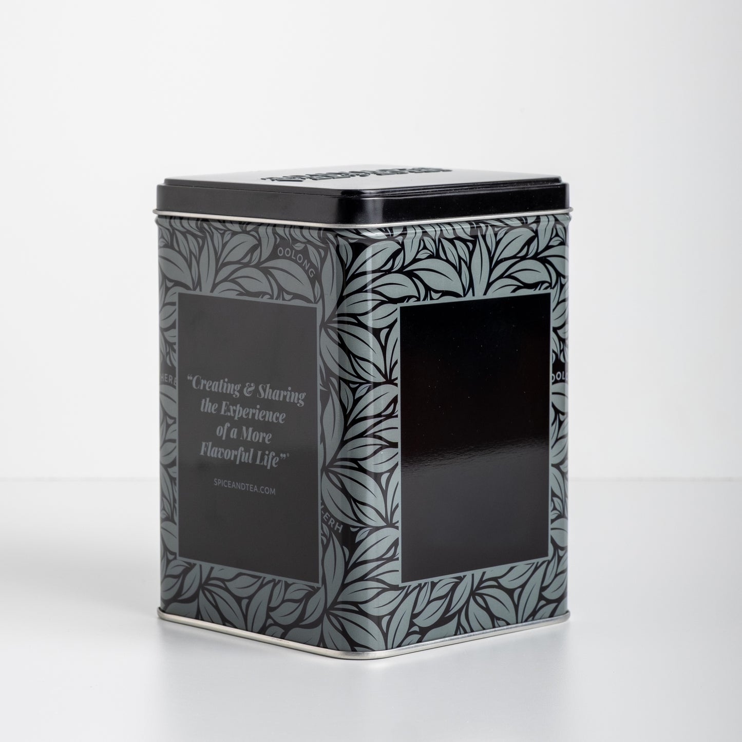 Decorative black grey and silver tea tin with leaf pattern on a white background. With text: Creating & Sharing the Experience of a More Flavorful Life SPICEANDTEA.com