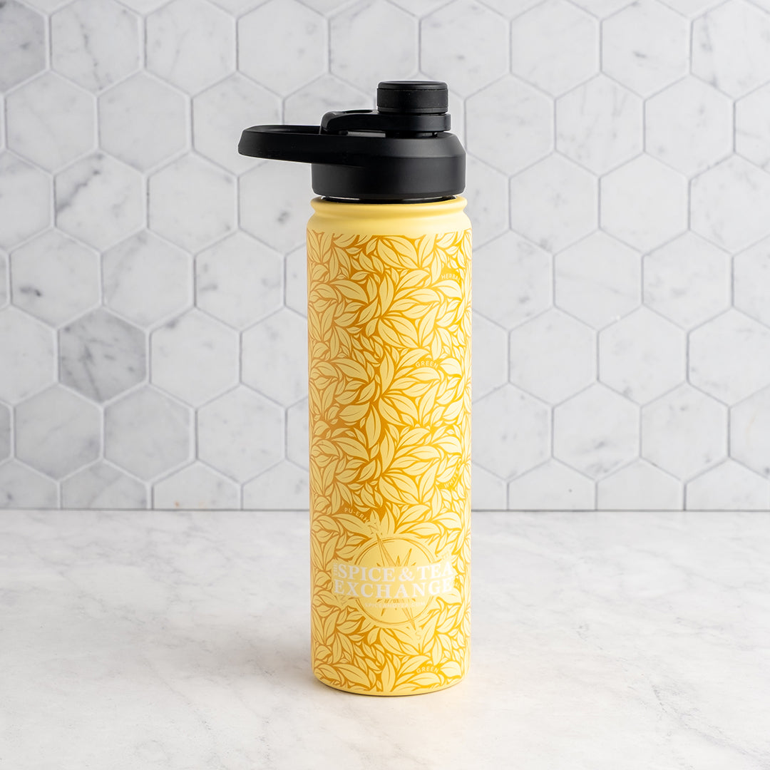 Yellow water bottle with black lid on a marble countertop