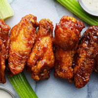 Party Wings 3 Ways (Kit): A selection of chicken wings tossed in a flavorful spice blend, served with sauce and celery.