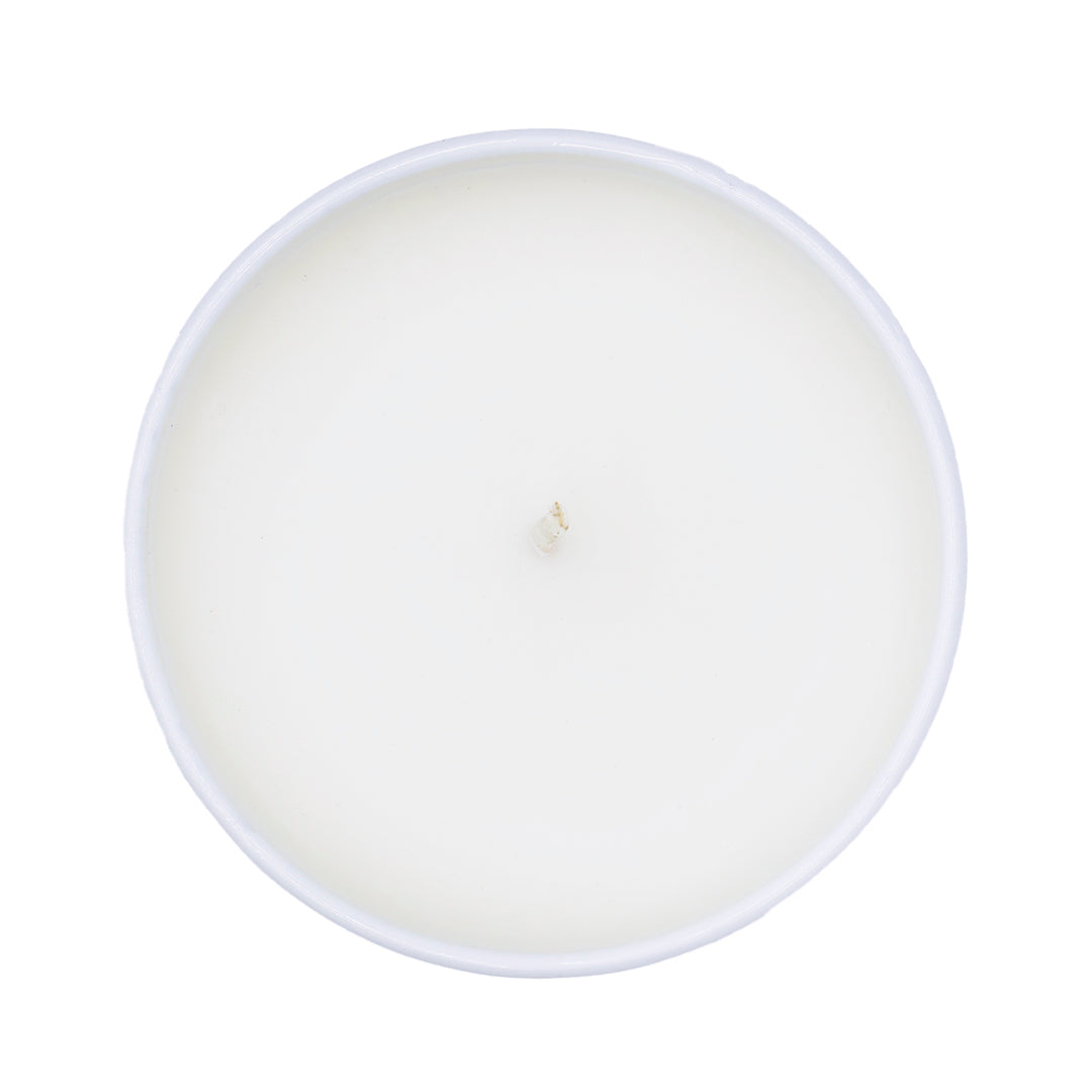 White candle in a white glass container on a white background