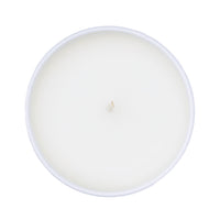 White candle in a white glass container on a white background