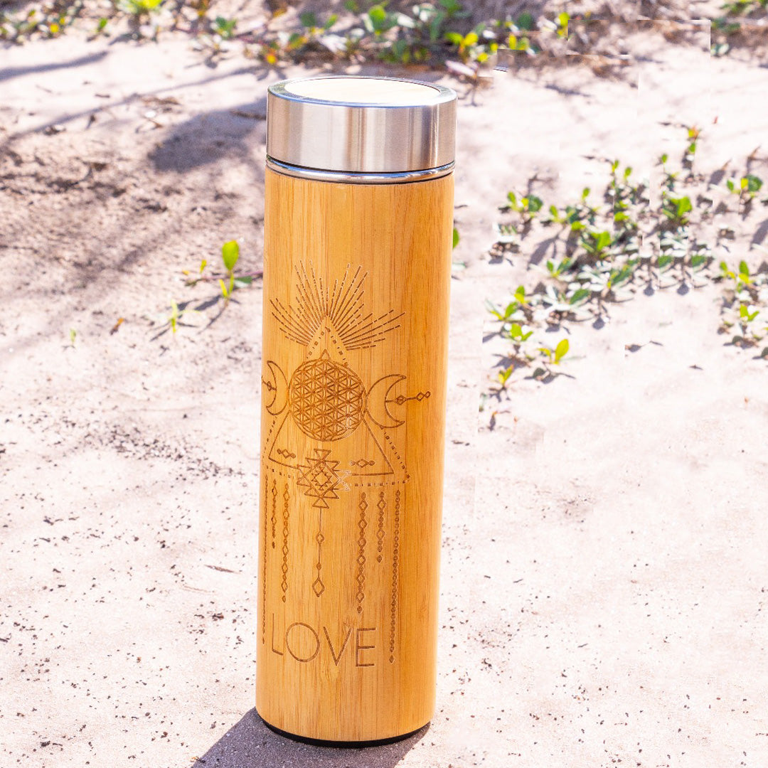 Bamboo tumbler with geometric designs and 'LOVE' engraving on a sandy background