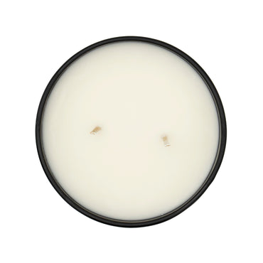 Round white candle in a black container on a white background