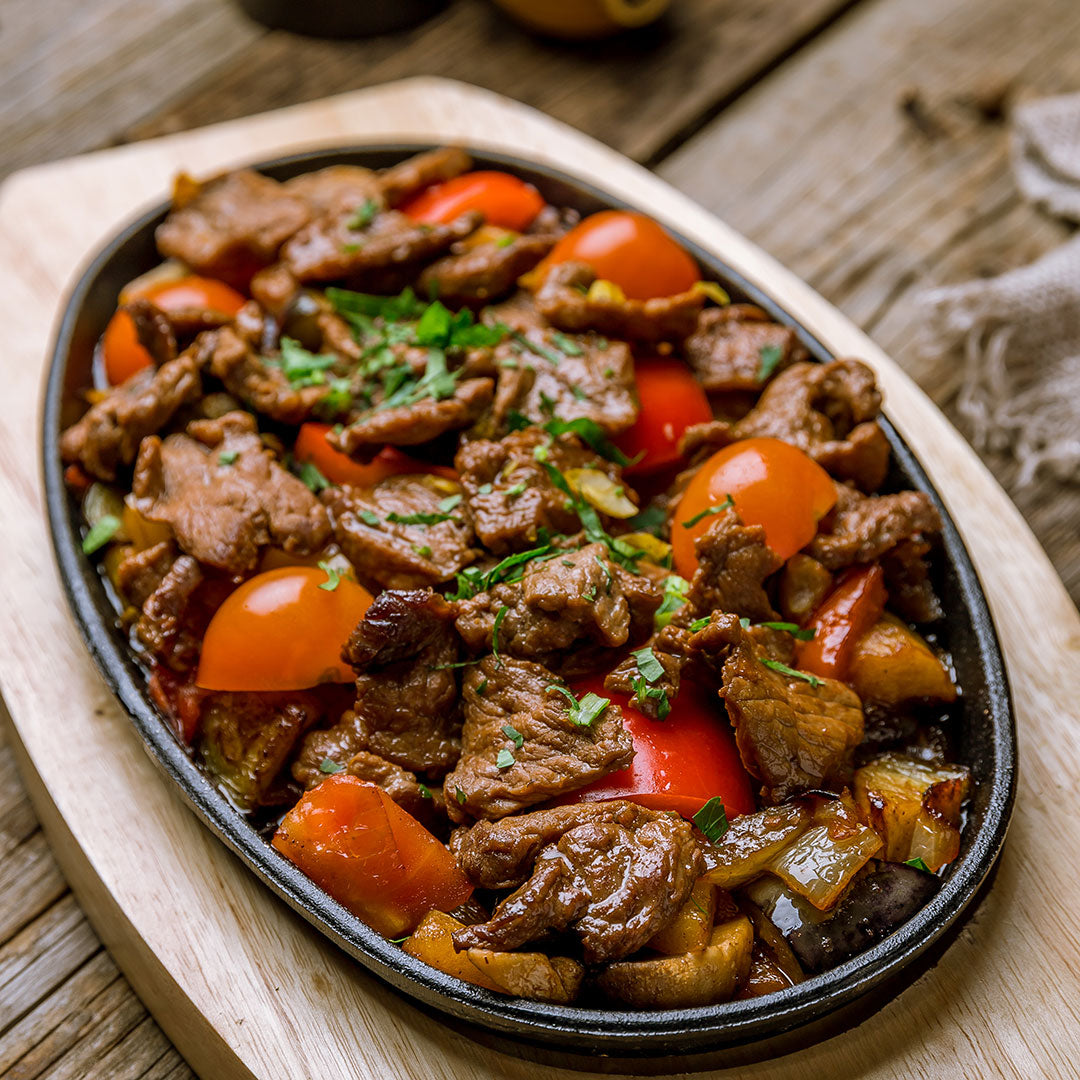 Plated dish of beef and vegetables on a wooden surface