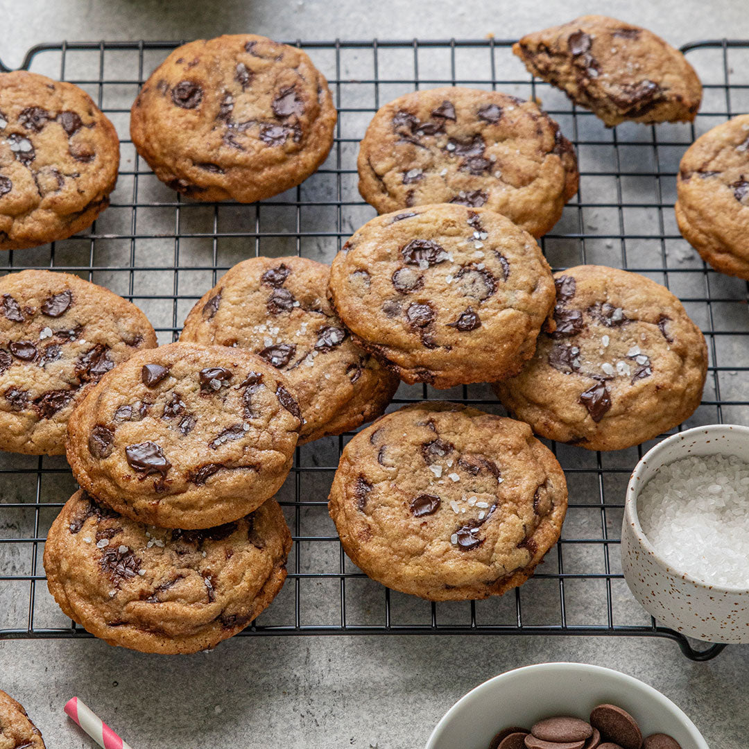 Chocolate chip cookies on a cooling rack sprinkled with sea salt