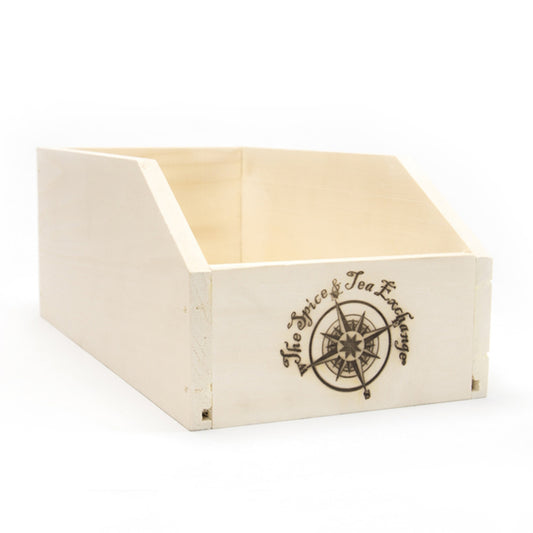 The Large Branded Wood Storage Box is a lightweight poplar box with an open top and cut-out front, ideal for storing spices. It displays a compass logo and "The Spice & Tea Exchange" on the front panel.