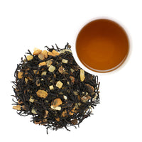 Caramel Macadamia Praline Black Tea in pile next to Caramel Macadamia Praline Black Tea brewed in white mug