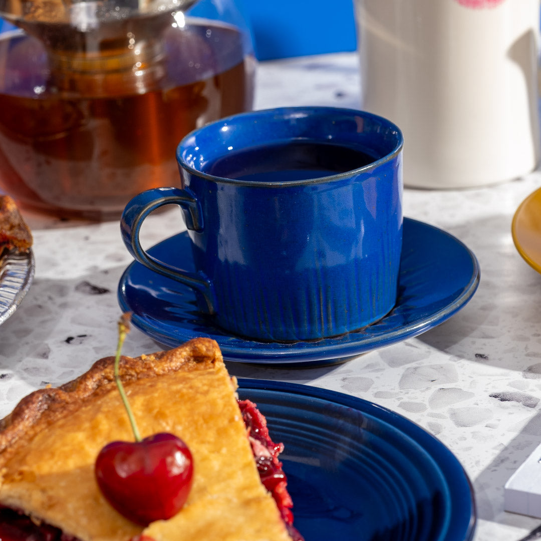 Cherry Pie Herbal Tea in blue mug next to piece of cherry pie