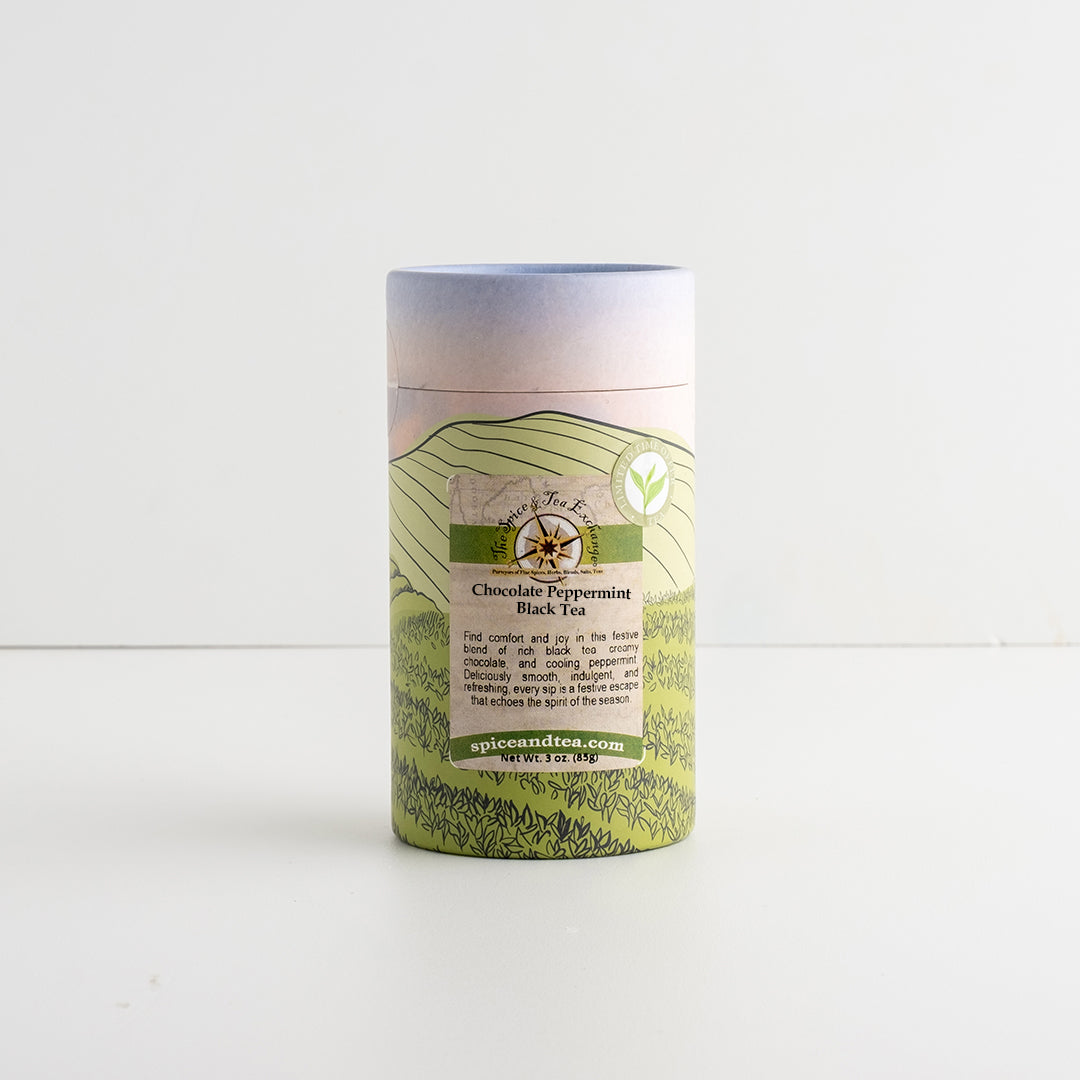 A cylindrical cardboard tube package of Chocolate Candy Cane Black Tea, featuring a pastel landscape label with green hills and a blue sky gradient, set against a plain white background.