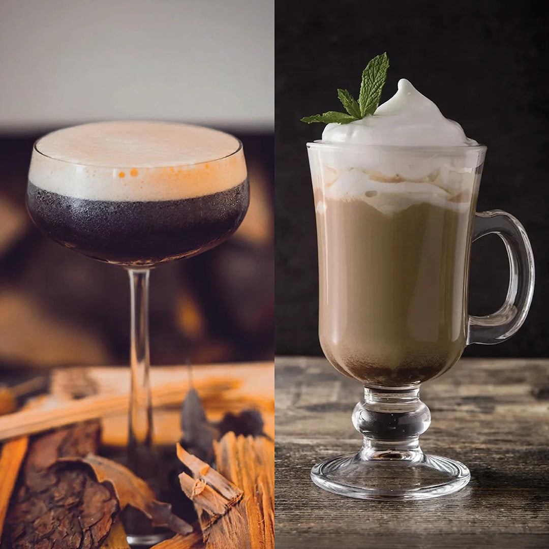 Two decorated cocktails shown side by side: on the left, a dark layered drink in a coupe glass topped with thick foam and a cinnamon stick; on the right, a layered coffee or latte drink in a handled glass mug topped with whipped cream and a mint leaf, set on a rustic wooden surface.