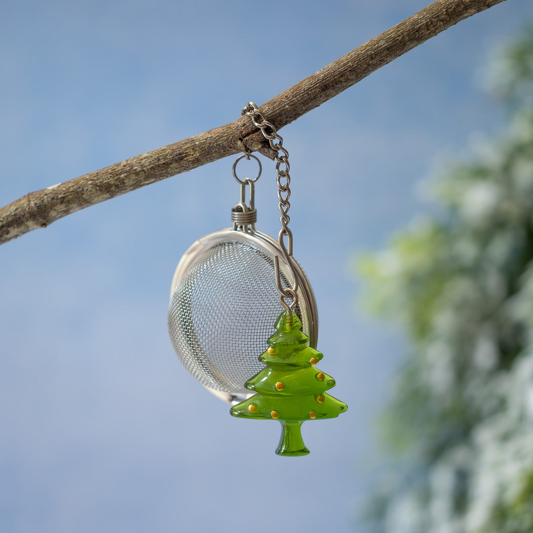  Christmas Tree Infuser hanging on branch with snowy background