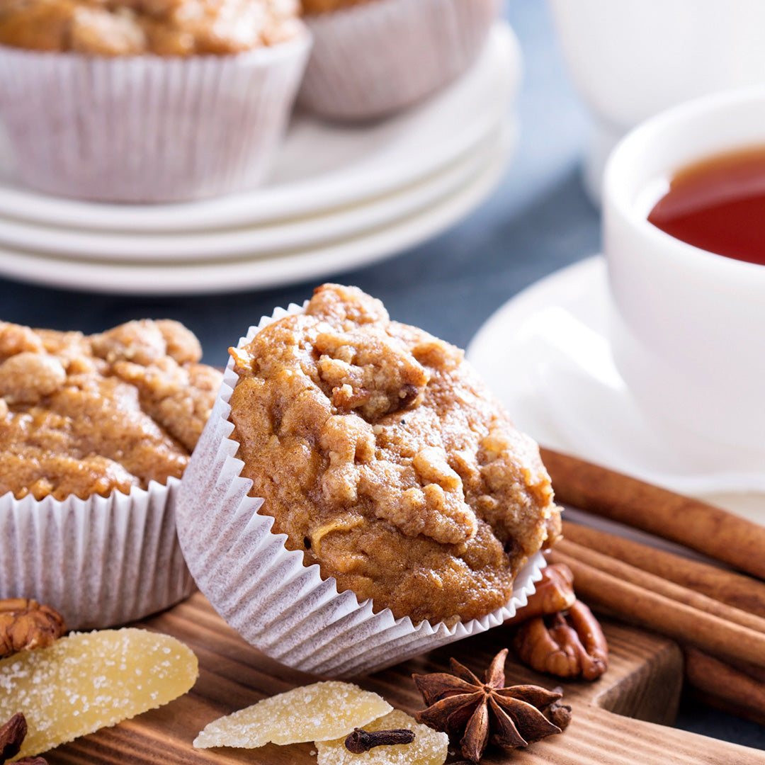 Muffins with cinnamon sticks and a cup of tea on a wooden board