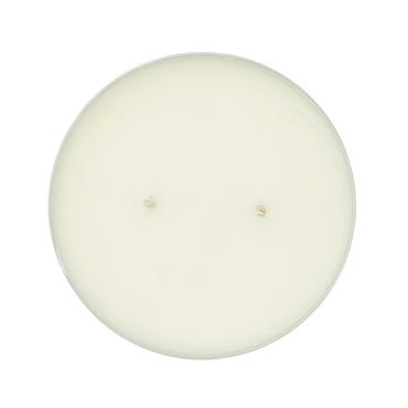 Top-down view of a round, single-wick candle with creamy off-white wax on a solid white background.