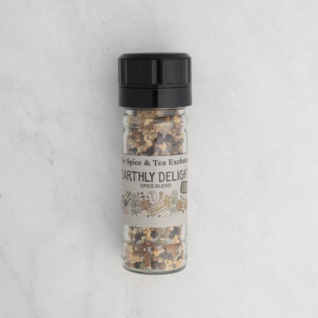 Earthly Delight Spice Blend comes in a clear jar with a black lid, showing its chunky herb and spice mix inside. The label displays herbs and spices on a white marble background. Ideal for adding bold flavor to meats, soups, and stews.