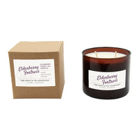 Candle and packaging with 'Elderberry Fortress' label on a white background