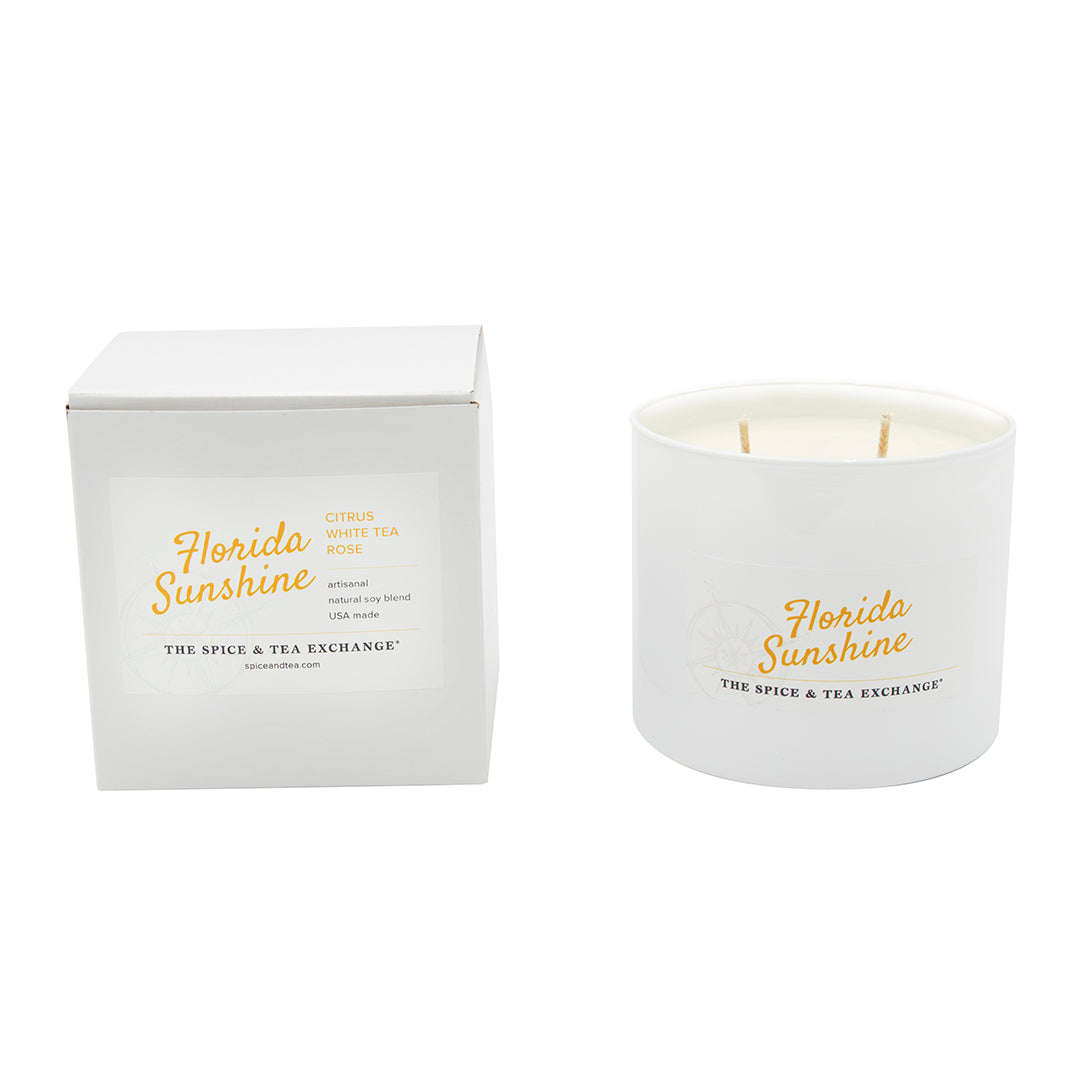 The Florida Sunshine Candle from The Spice & Tea Exchange is a white soy jar candle with two wicks. Both the candle and its box are labeled, featuring a citrusy scent with notes of white tea and rose.
