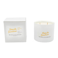The Florida Sunshine Candle from The Spice & Tea Exchange is a white soy jar candle with two wicks. Both the candle and its box are labeled, featuring a citrusy scent with notes of white tea and rose.