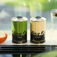 Basil Extra Virgin Olive Oil and Garlic Extra Virgin Olive Oil sitting on window ledge.