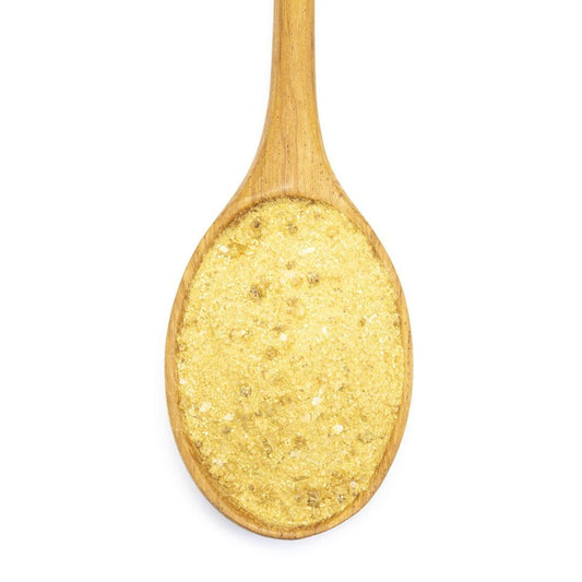 A wooden spoon filled with Ginger Teriyaki Seasoning, photographed from above on a white background, perfect for adding bold flavor to a stir-fry.