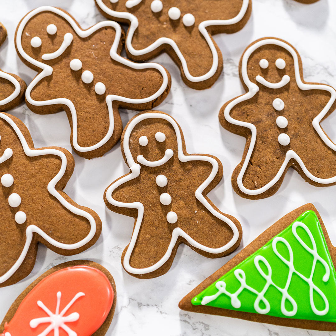 Decorative gingerbread cookies with icing on a white surface