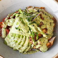 Plated dish with green sauce, chicken, and vegetables on a white plate.