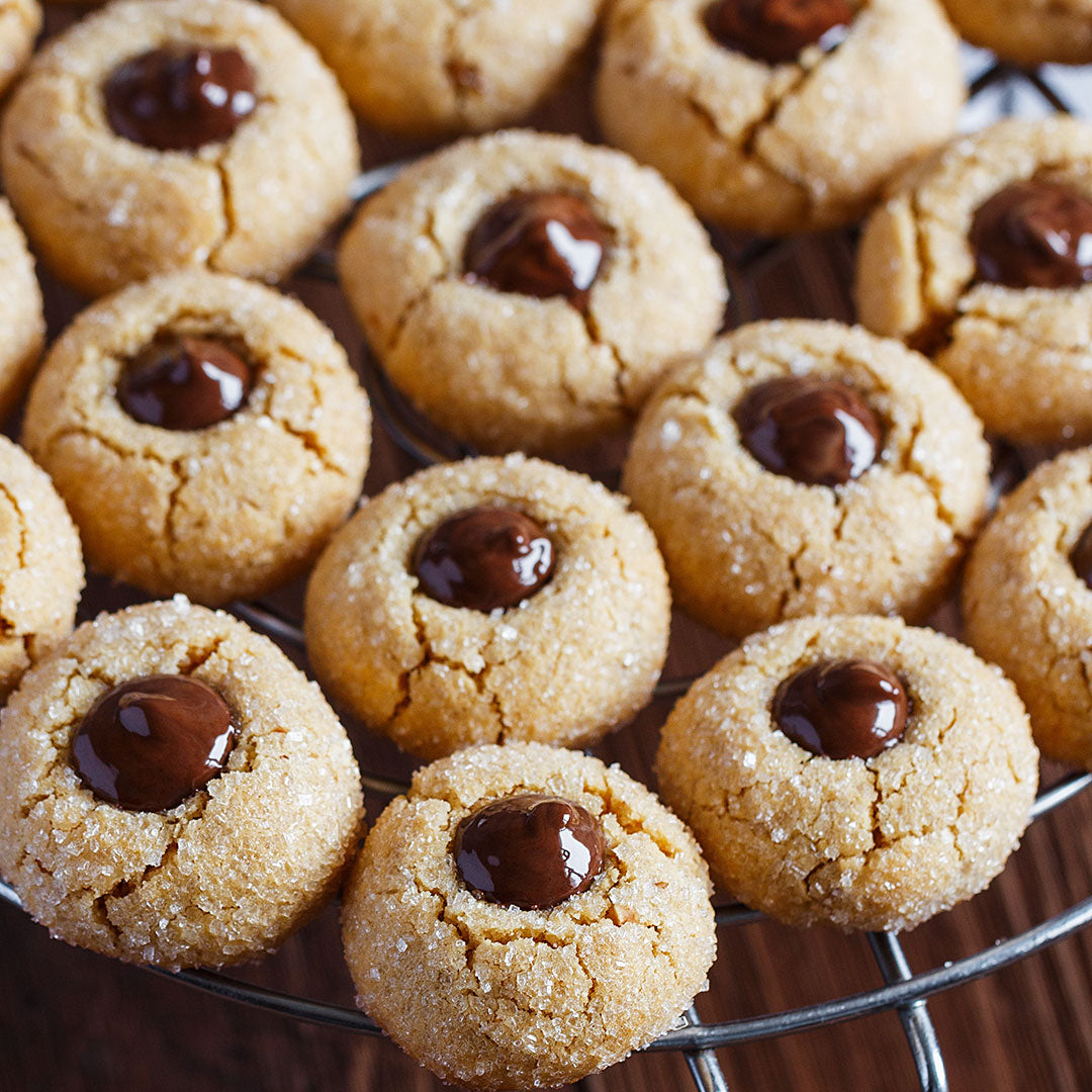 Peanut butter cookies with chocolate centers on a cooling rack
