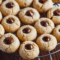 Peanut butter cookies with chocolate centers on a cooling rack