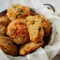 Baked biscuits with herbs in a basket lined with paper