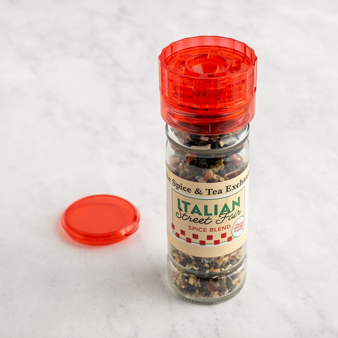 Spice jar with red lid and 'Italian Street Fire' label on a light gray background next to red lid