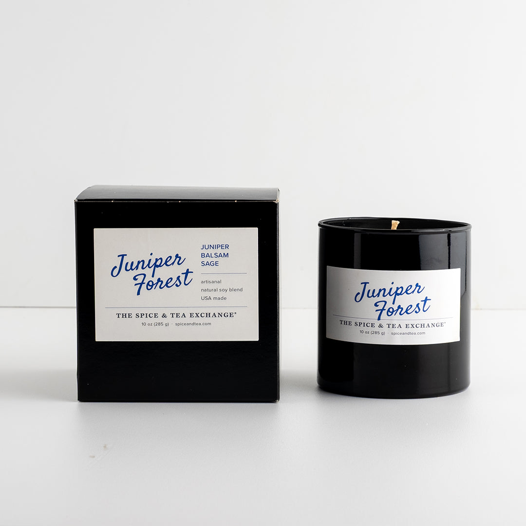 Juniper Forest Candle in black glass vessel next to black box