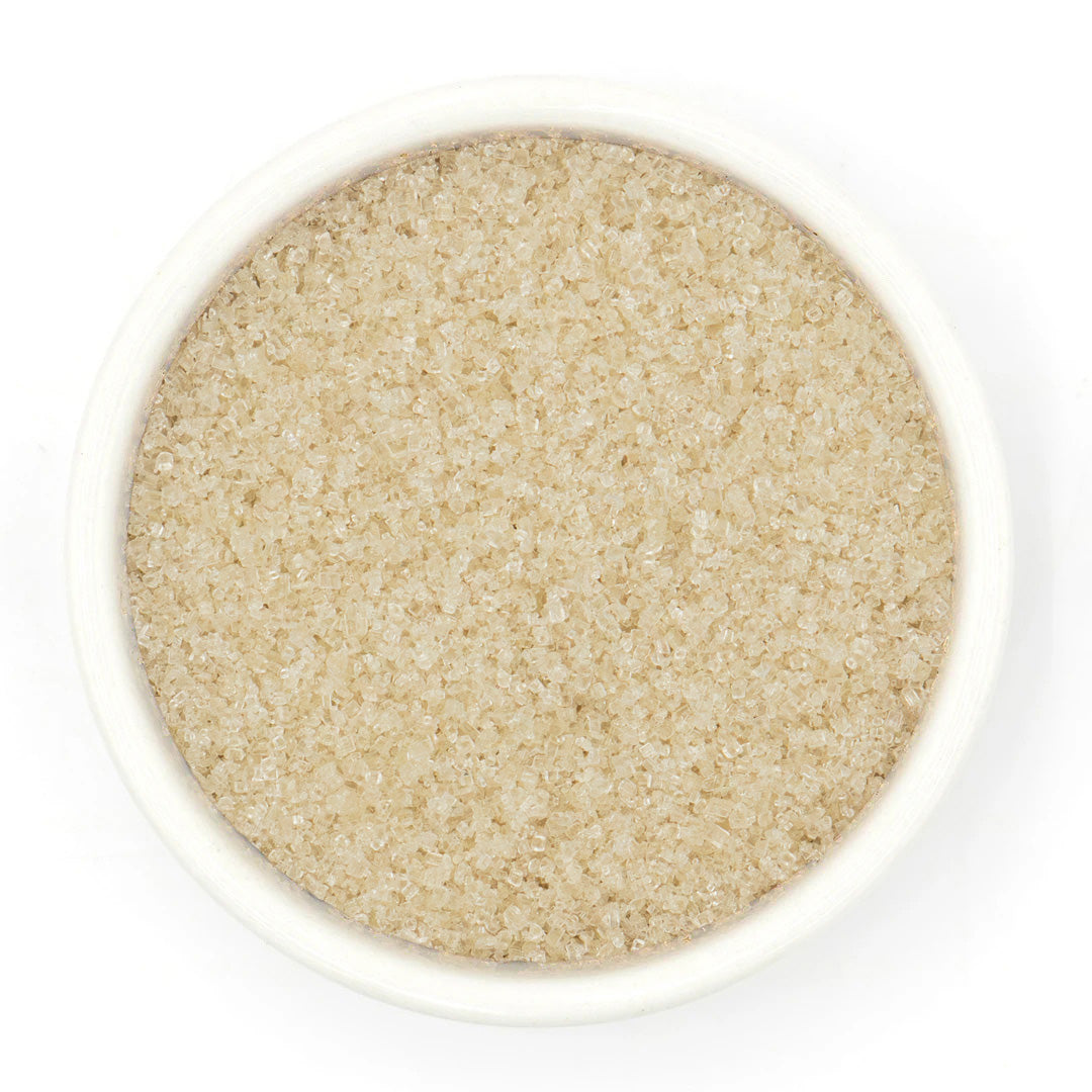 Close-up of a bowl filled with Lavender Sugar on a white background