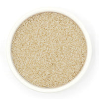 Close-up of a bowl filled with Lavender Sugar on a white background