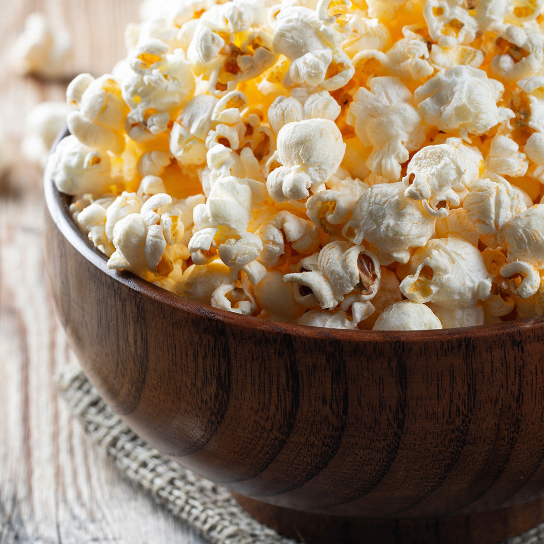 Popcorn in a wood bowl on a wood table