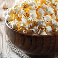 Popcorn in a wood bowl on a wood table