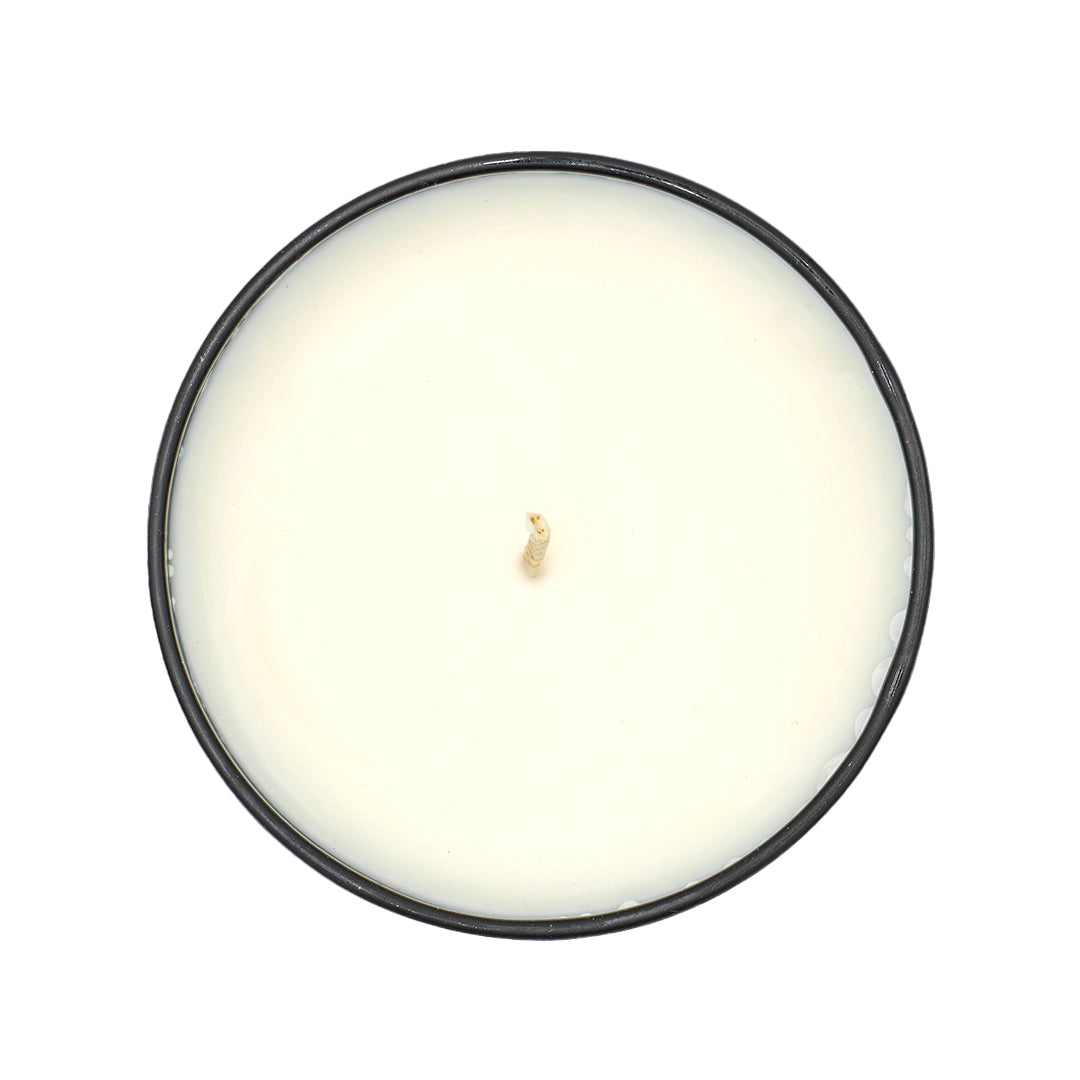 Round candle with an amber glass holder on a white background