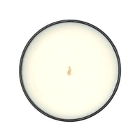 Round candle with an amber glass holder on a white background