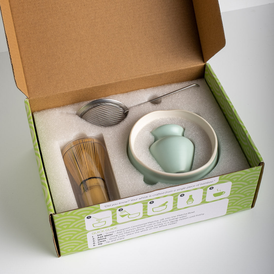 Tea-making set with a: Matcha Bowl (ceramic), Matcha Whisk (bamboo), Whisk Holder (ceramic), Matcha Sieve (stainless steel), Matcha Scoop (bamboo) in a box on a white background