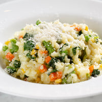Vegetable risotto with parmesan cheese in a white bowl
