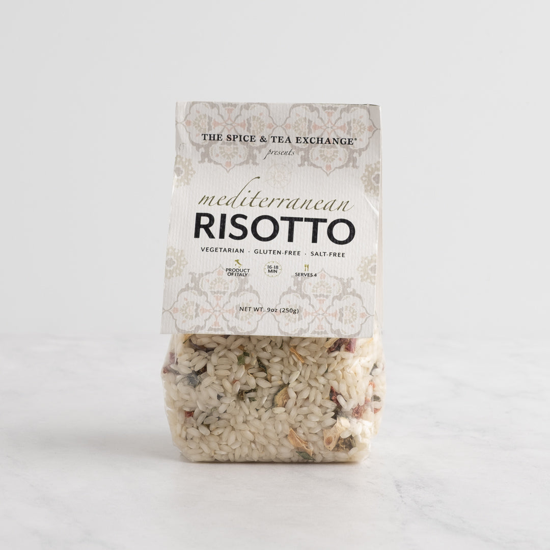 A package of Mediterranean Risotto from The Spice & Tea Exchange, featuring a white label with ornate detailing and a clear lower section showing the mixed rice inside, set against a light gray background.