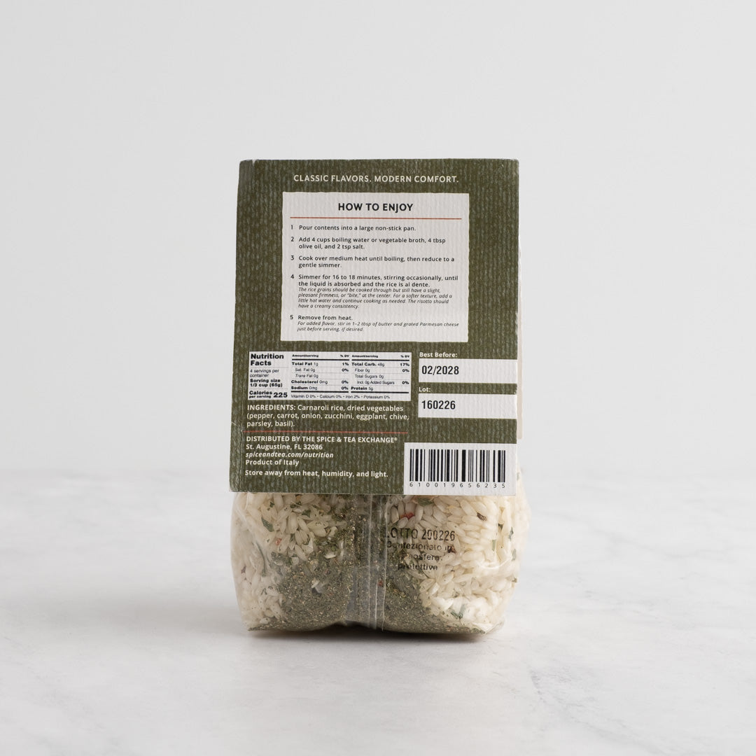A package of Mediterranean Risotto from The Spice & Tea Exchange, featuring a white label with ornate detailing and a clear lower section showing the mixed rice inside, set against a light gray background. Back side.