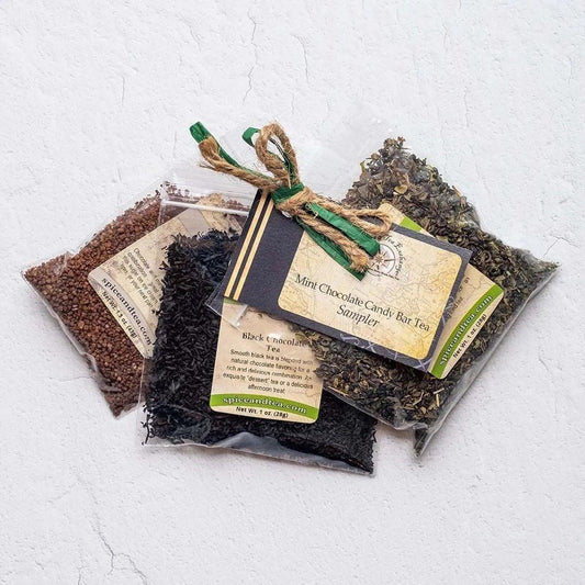 Three clear packets of loose tea leaves tied with twine and a green ribbon, each labeled and accompanied by a tag reading “Mint Chocolate Candy Bar Tea Sampler”—ideal for crafting a candy-flavored beverage.