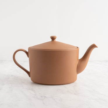 Mocha mousse teapot on a light marble surface