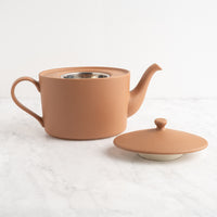 Ceramic mocha mousse teapot with lid on a white background
