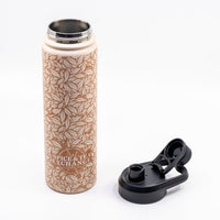A tall insulated water bottle with a beige and brown leaf pattern, shown next to its black flip-top lid on a white background. The bottle features the 'SPICE & TEA EXCHANGE' logo near the bottom.
